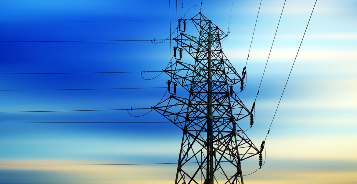 Electrical pylon and energy lines against dusk sky