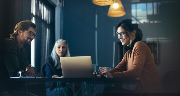 Woman giving a presentation over laptop to colleagues at office