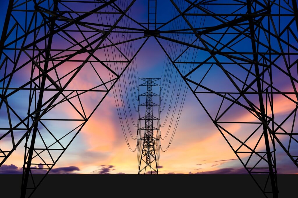 High Voltage energy tower and electric wires at dusk